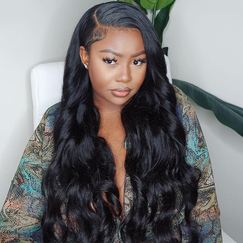 Woman with tattoos on her arm wearing a red top, modeling an Ishow Beauty body wave HD lace front wig made of 100% human hair in natural black.