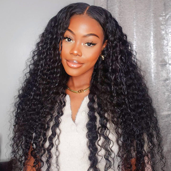 Woman wearing long natural black deep wave wig with a 13x4 frontal HD lace in an indoor setting, showcasing the deep wave texture and pre-plucked hairline.