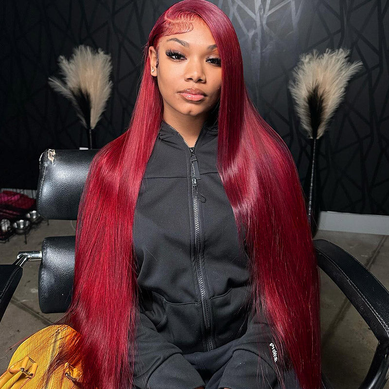 Long Straight 99J Burgundy Hair Woman Seated in Salon, Wearing Black Jacket