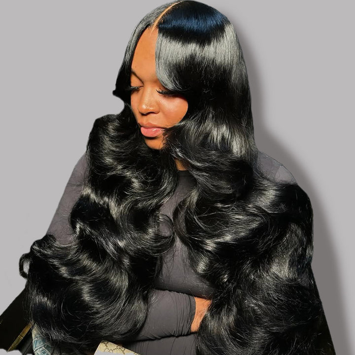 Woman with long, body wave human hair wig against a gray background