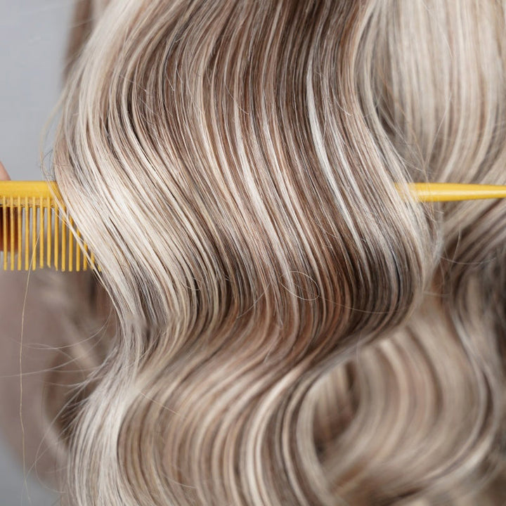 Blonde Highlight Body Wave Hair With Loose Curls Styled Using a Yellow Comb
