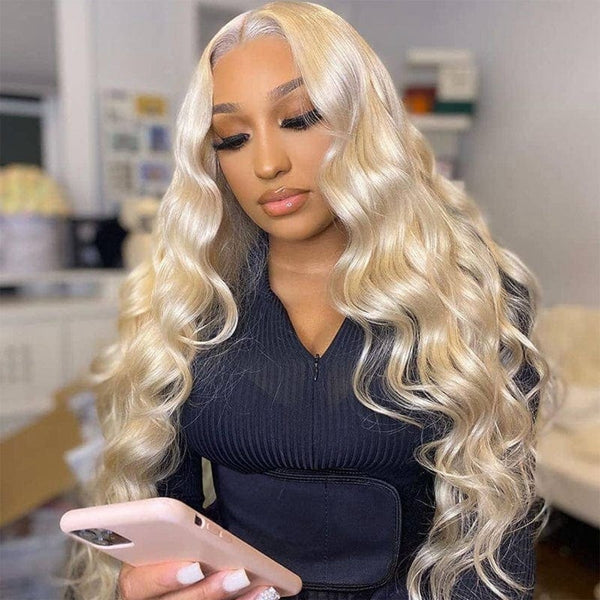 Woman in Honey Blonde Body Wave Wig, Holding Smartphone, Wearing a Black Outfit