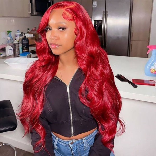 Model with vibrant red body wave Ishow glueless wig, featuring 13x4 pre-cut HD lace front and baby hairs, seated in a stylish room.