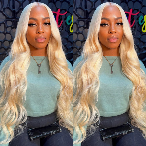Woman With Long Honey Blonde Body Wave Wig, Wearing a Green Top and Smiling