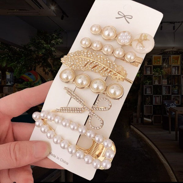 Various handmade pearl hair clips in different designs including large pearls, rectangular, straight, ribbon shaped, feather shaped, and round with intricate details.