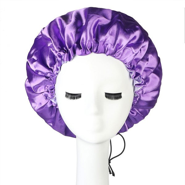 Purple satin bonnet with adjustable elastic band displayed on mannequin head. Satin care hat for hair protection and maintenance.