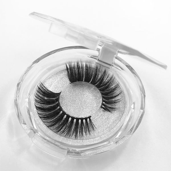 Open plastic case and round container displaying dramatic 3D mink eyelashes with fluffy, voluminous texture. Suitable for enhancing makeup looks and cruelty-free.