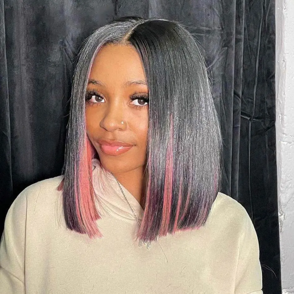 Woman in Straight Bob Wig With Peekaboo Pink Highlights Against a Dark Backdrop