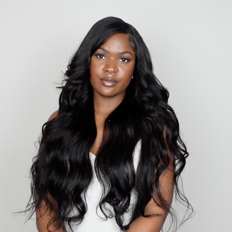 Woman wearing a deep wave black wig from Ishow Beauty, showcasing pre-plucked hairline and natural curls in a center part.