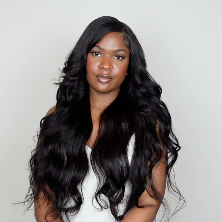 Woman wearing a deep wave black wig from Ishow Beauty, showcasing pre-plucked hairline and natural curls in a center part.