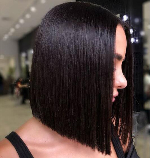 Woman wearing a straight short bob lace front wig with a middle part in natural black color. The wig provides a natural look, perfect for a stylish and elegant appearance.