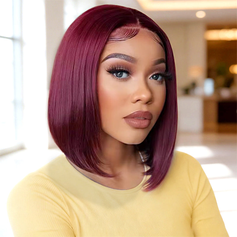 Woman with burgundy bob hair wig wearing a yellow top indoors.