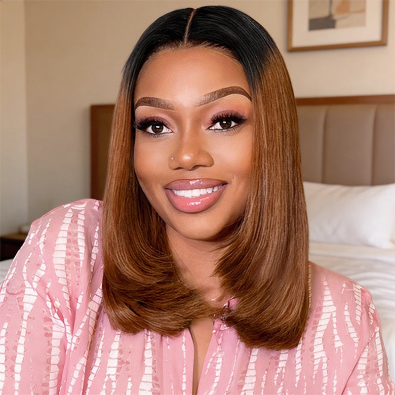 Woman with a ombre color straight bob wig wearing a pink top in a bedroom setting