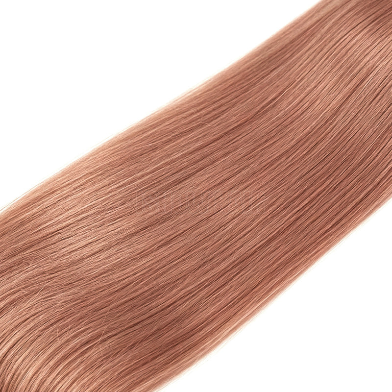 A Close-Up Of Straight, Silky Human Hair Extensions, Shown Diagonally Against A Solid White Background.